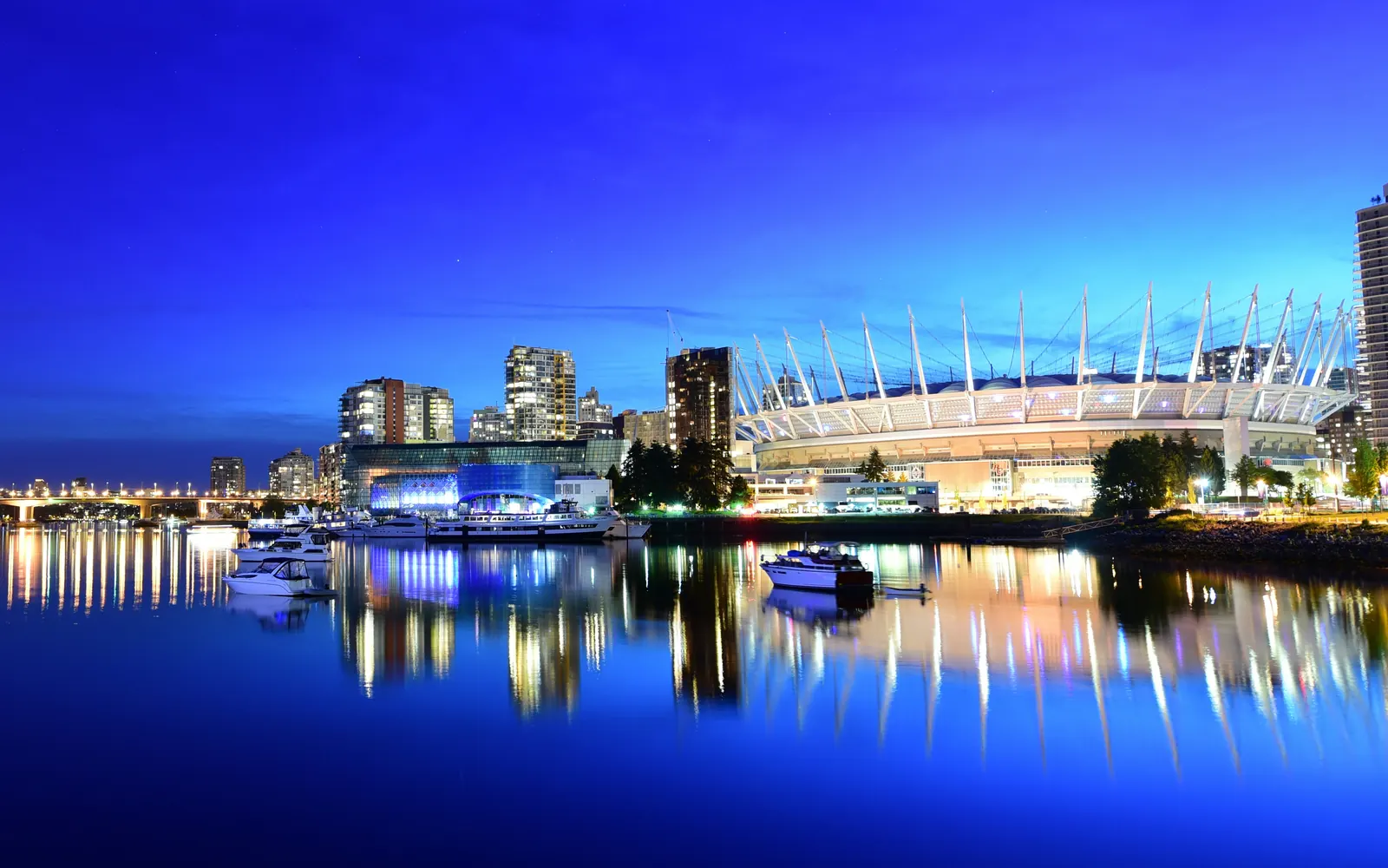 BC Place stadium and the False Creek skyline reflected in calm water at dusk, Vancouver